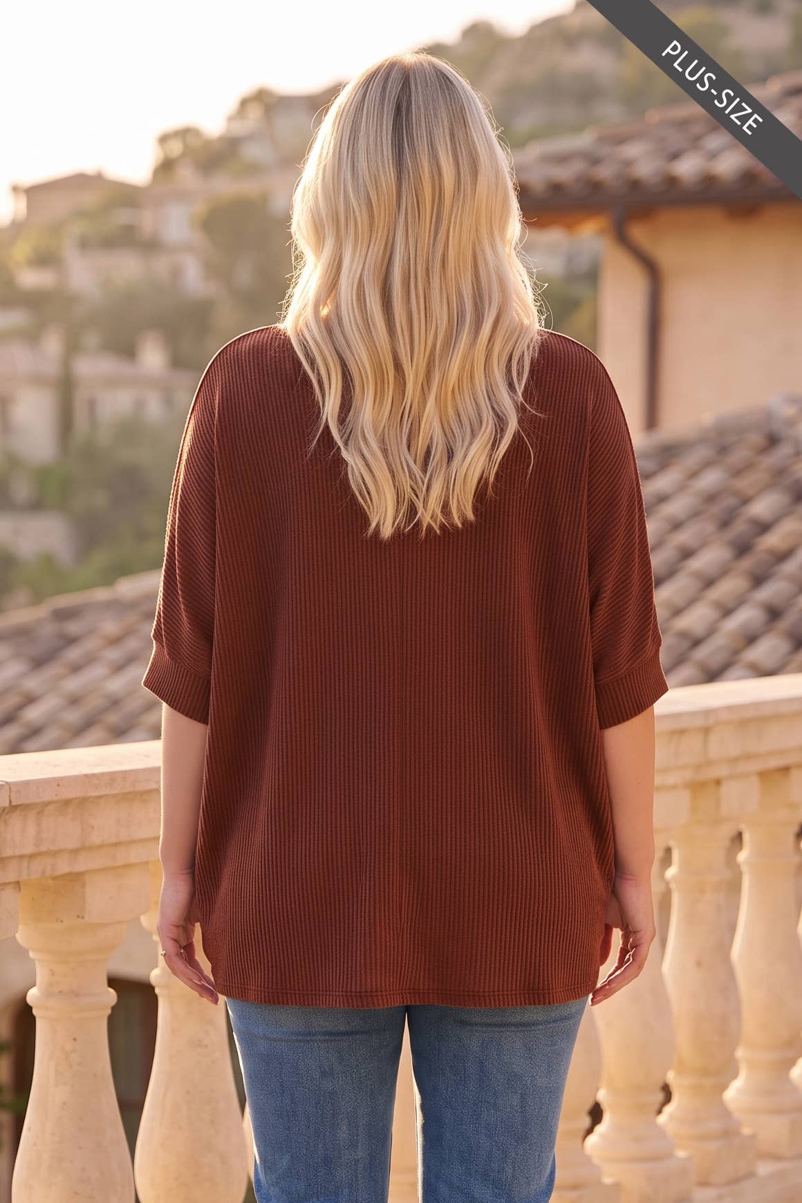 Back view of plus-size rust ribbed knit top with relaxed oversized fit