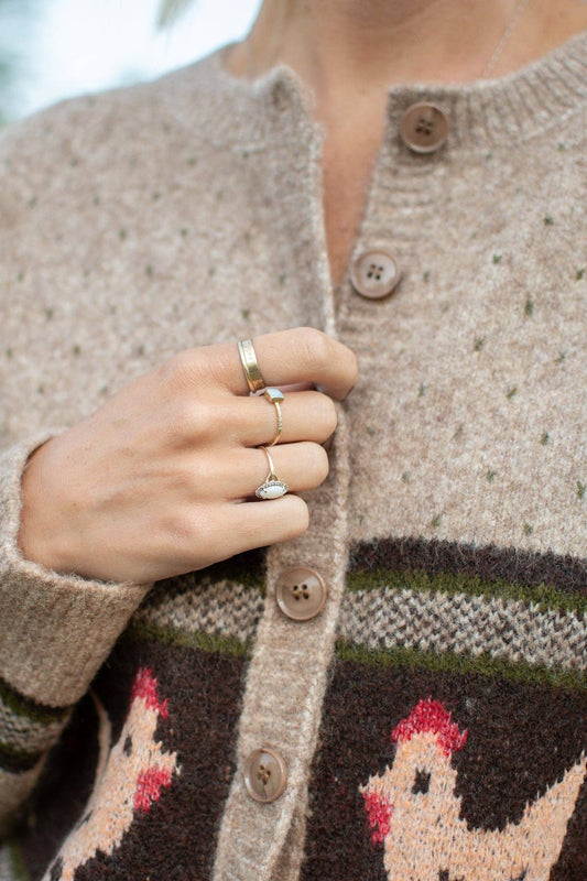 Close-up of vintage-inspired cream chicken knit pattern on chocolate brown band of women's farmhouse cardigan sweater.