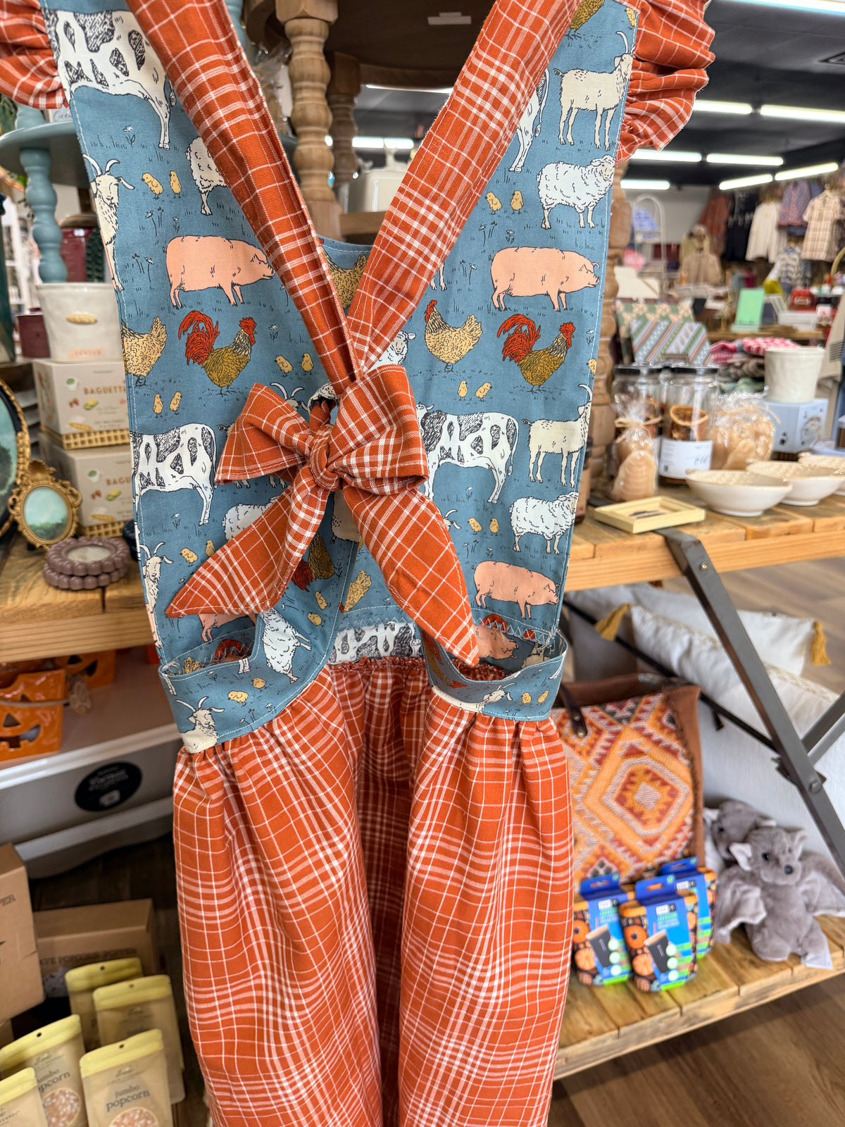Freckles on the Side crossback apron with rust plaid ruffled straps and tie back bow