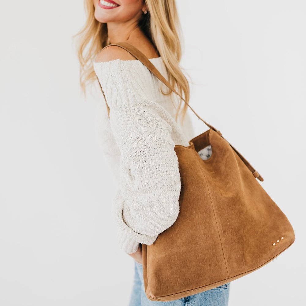 Woman carrying Evie camel suede hobo shoulder bag