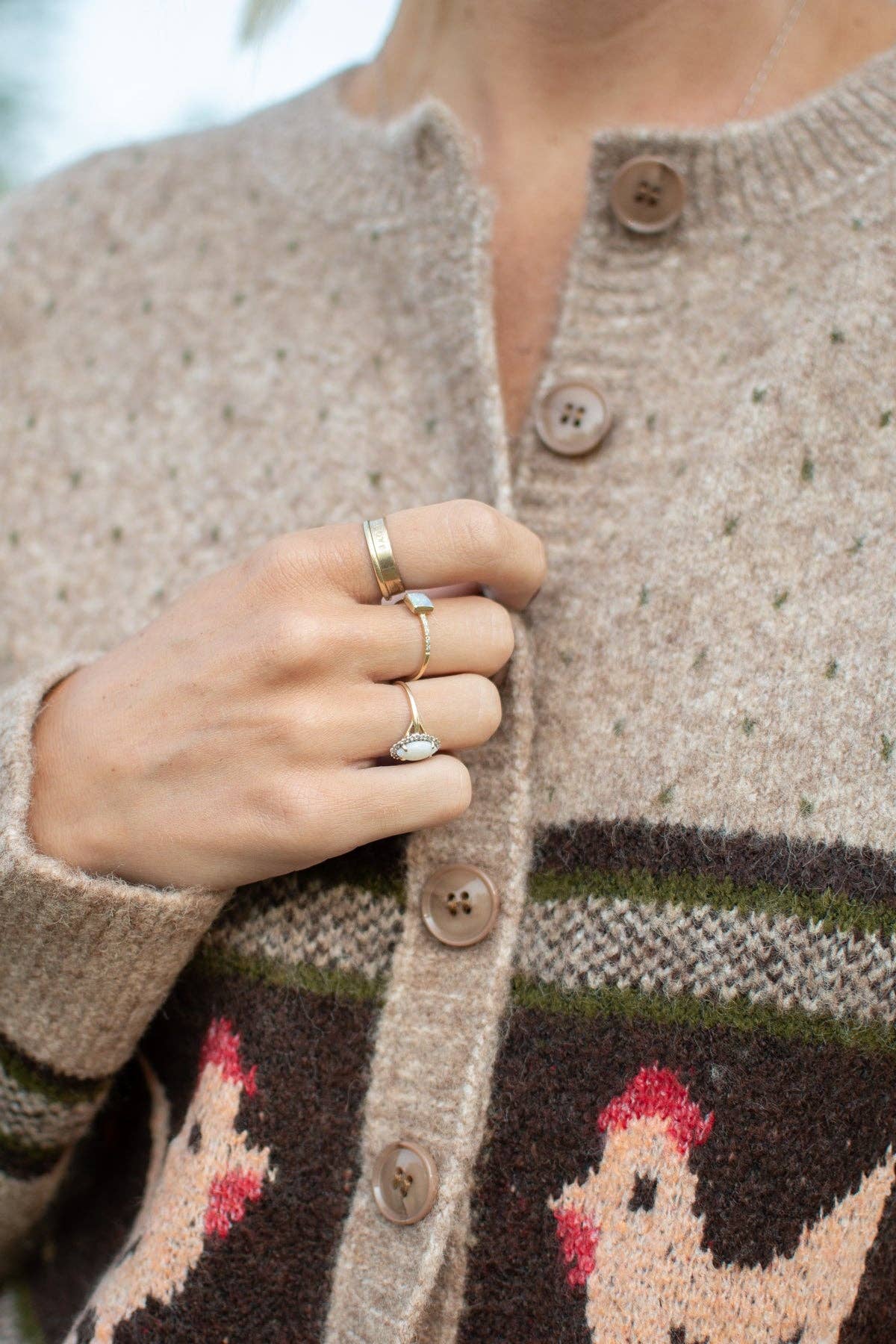 Close-up of vintage-inspired cream chicken knit pattern on chocolate brown band of women's farmhouse cardigan sweater.