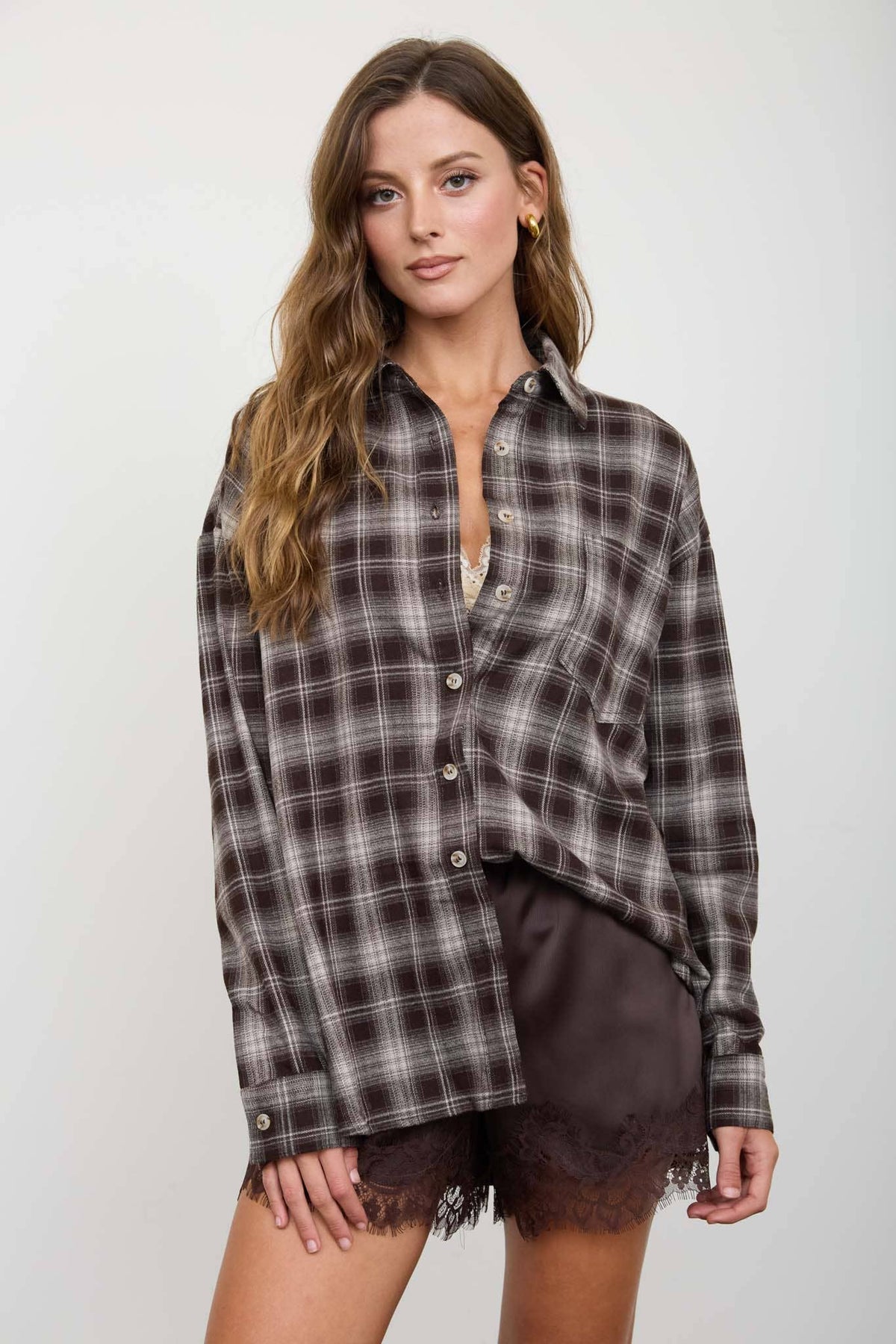 Close-up of chocolate brown plaid button-down shirt and front pocket
