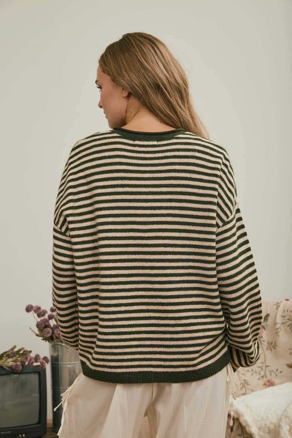 Back view of green and cream striped relaxed fit women’s sweater