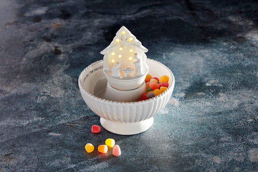 Mud Pie white ceramic light-up Nativity sitter displayed in a Christmas candy bowl with colorful holiday sweets.
