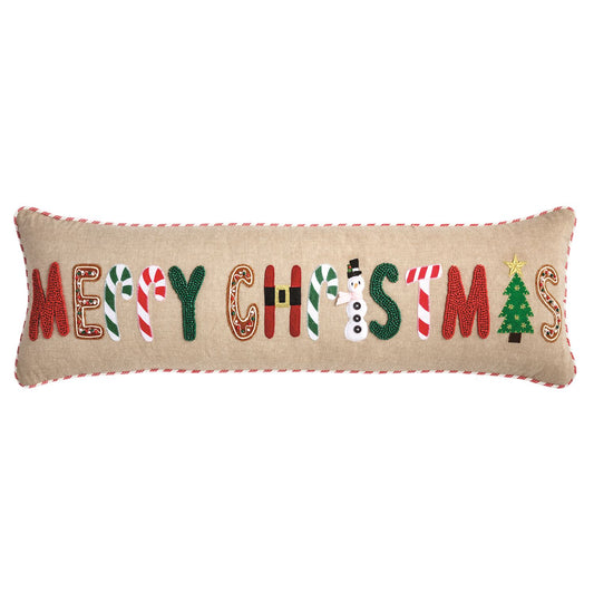 Mud Pie Merry Christmas long lumbar pillow featuring festive beaded and felt appliqué letters, natural chambray fabric, and red striped piping.