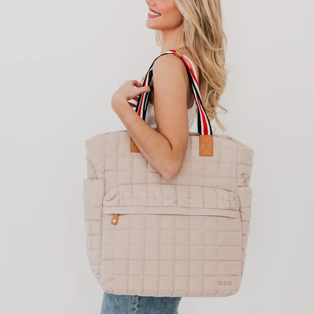 Tan Tenley quilted travel tote bag with striped shoulder handles