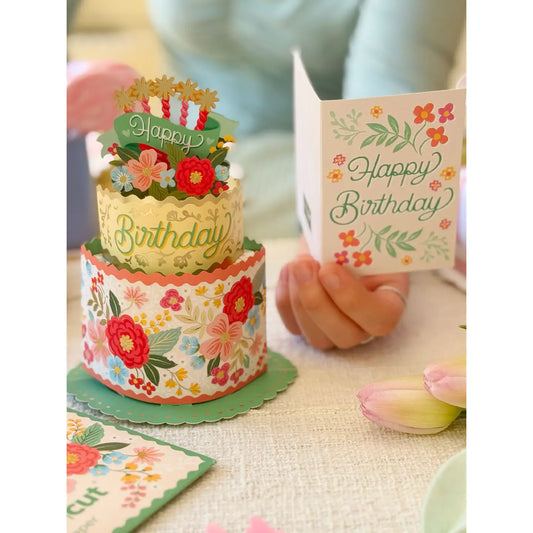 FreshCut Paper Mini Blooming Birthday Cake 3D pop-up greeting card with colorful floral two-tier cake, birthday candles, and matching Happy Birthday notecard