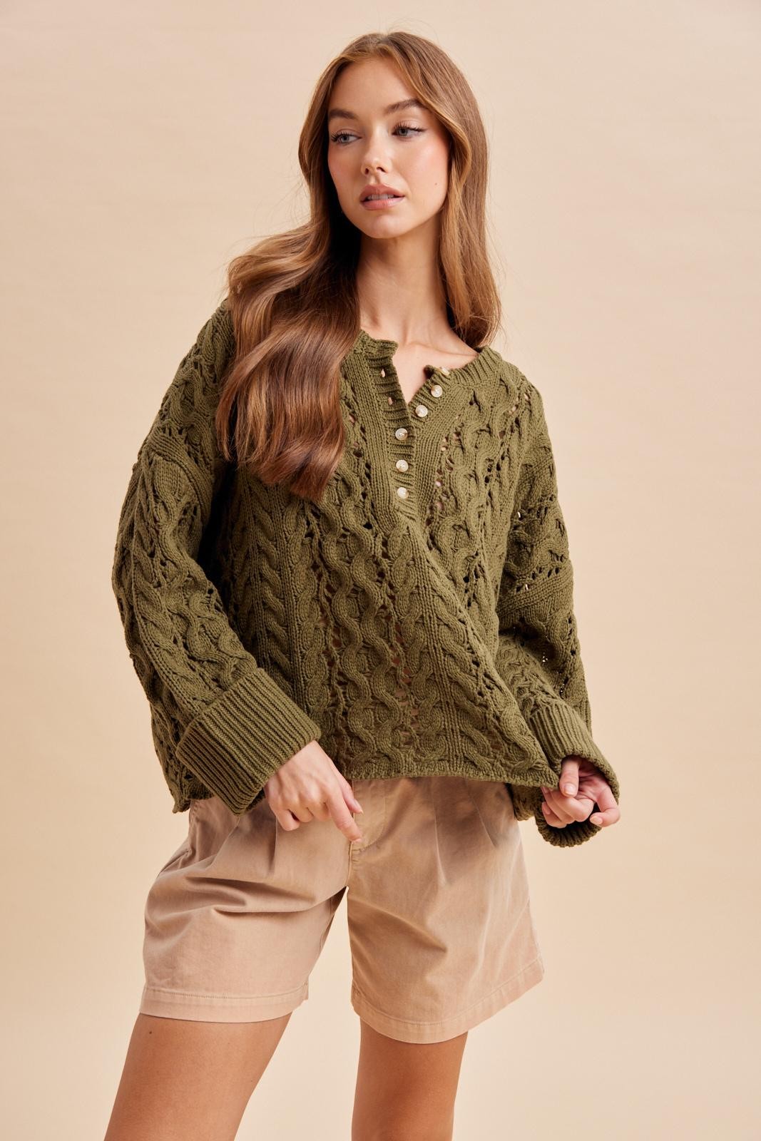 Women's olive green chunky cable knit Henley sweater with button neckline and ribbed cuffs