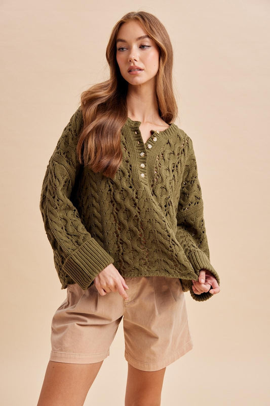 Women's olive green chunky cable knit Henley sweater with button neckline and ribbed cuffs