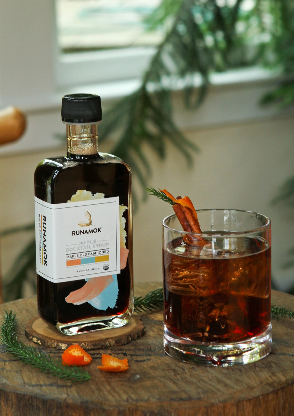 Runamok Maple Old Fashioned Cocktail Mixer with Old Fashioned cocktail and orange garnish