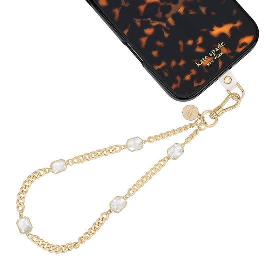 Kate Spade New York gold chain phone charm with clear crystal accents attached to phone case