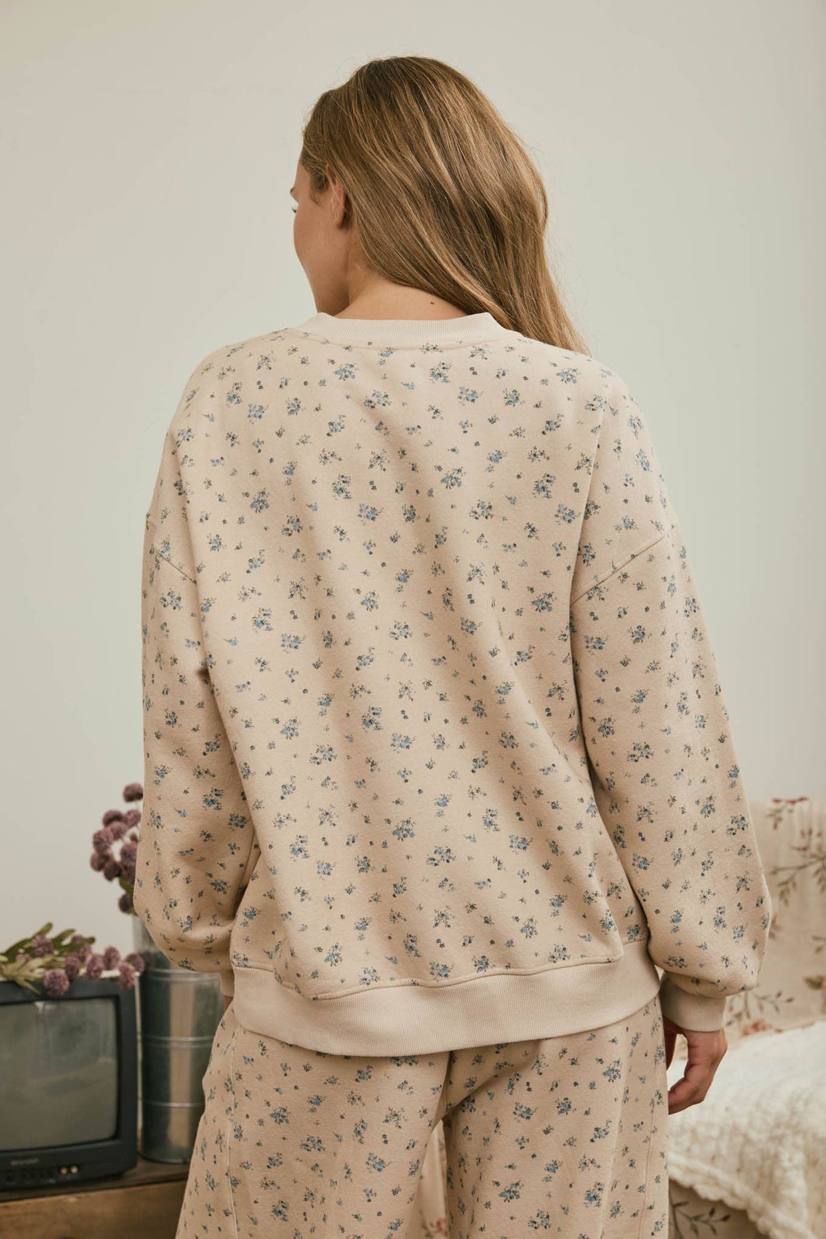 Back view of women’s blue floral crewneck sweatshirt with relaxed fit