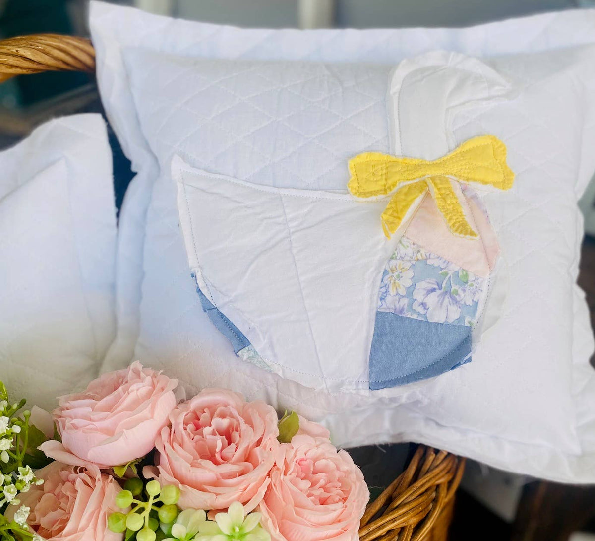 Porch goose pillow handmade from upcycled vintage quilt with yellow bow, styled with pink flowers for cottage farmhouse decor
