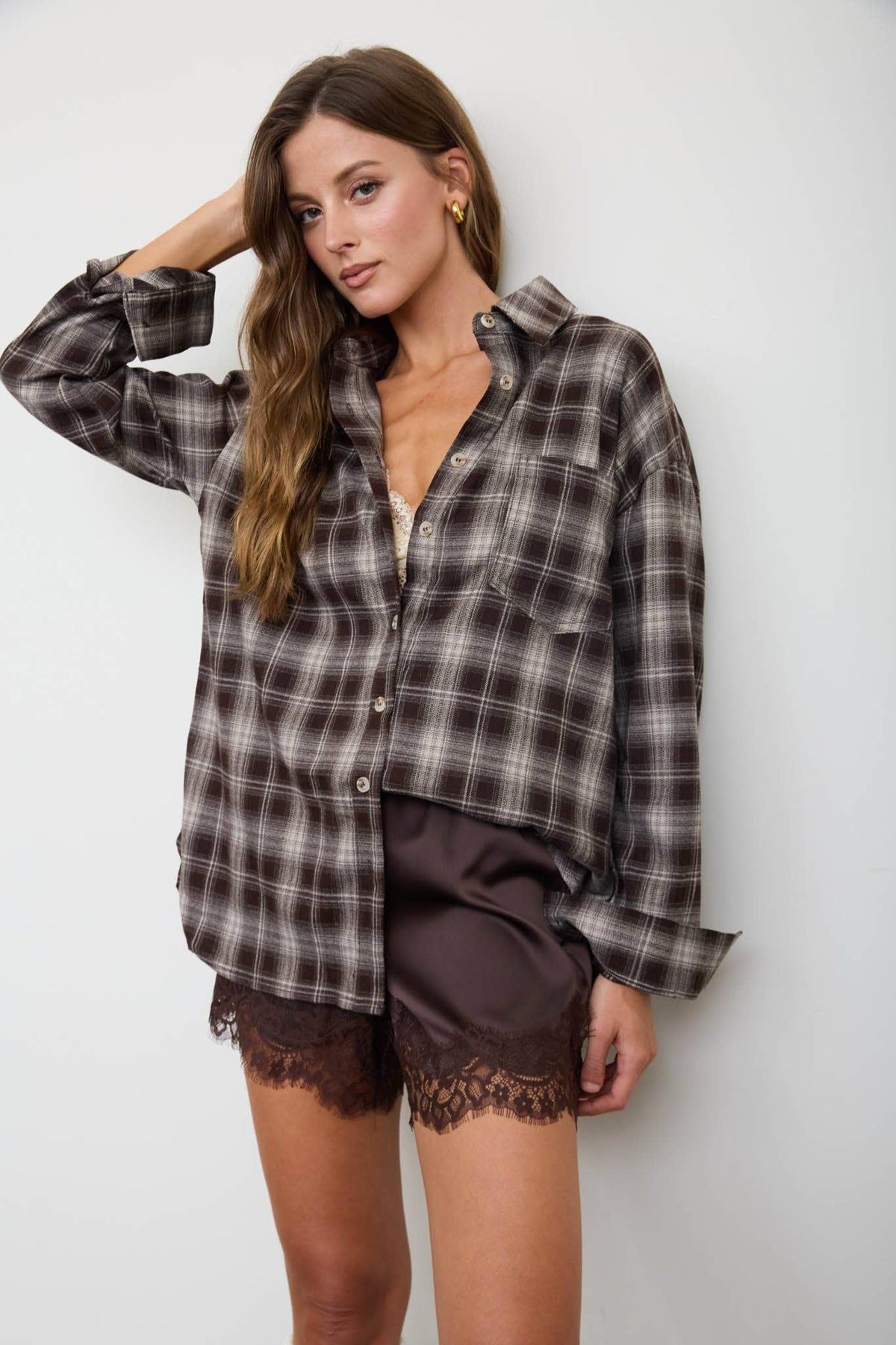 Back view of women’s brown plaid button-down shirt with relaxed fit