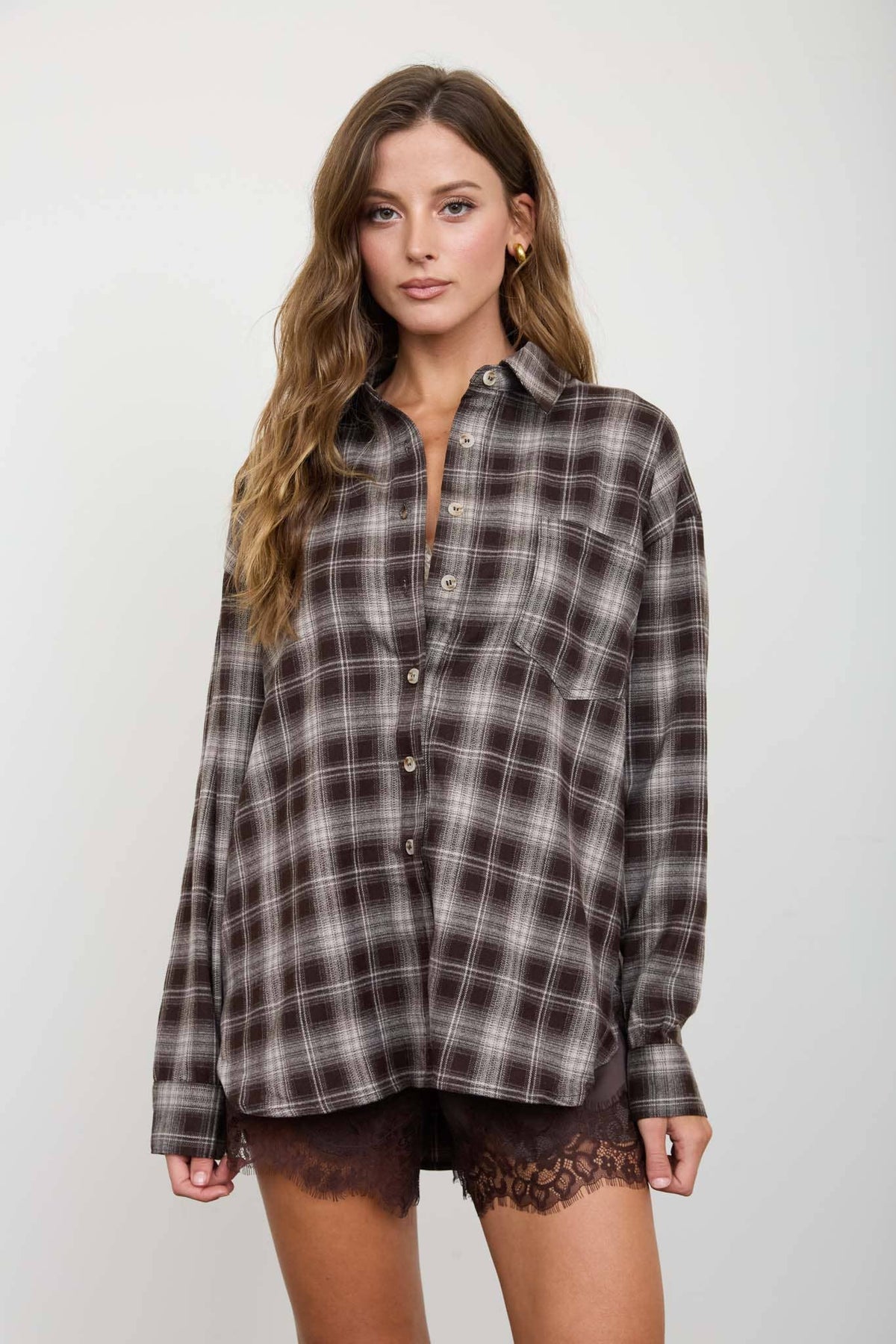Close-up of chocolate brown plaid button-down shirt and front pocket