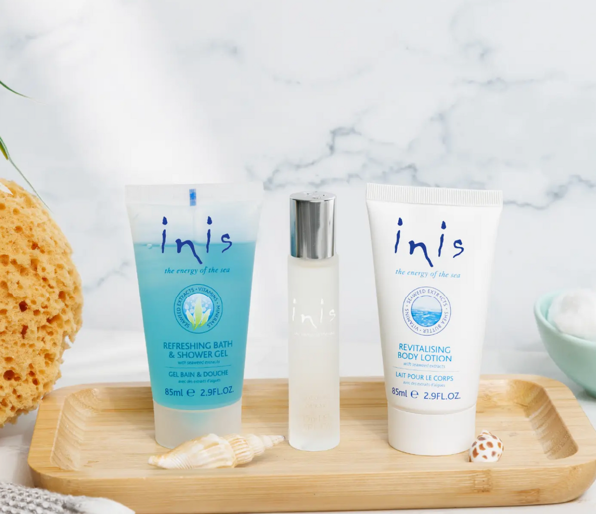 Inis Trio Gift Set travel-size shower gel, cologne and body lotion displayed on wooden tray with seashells