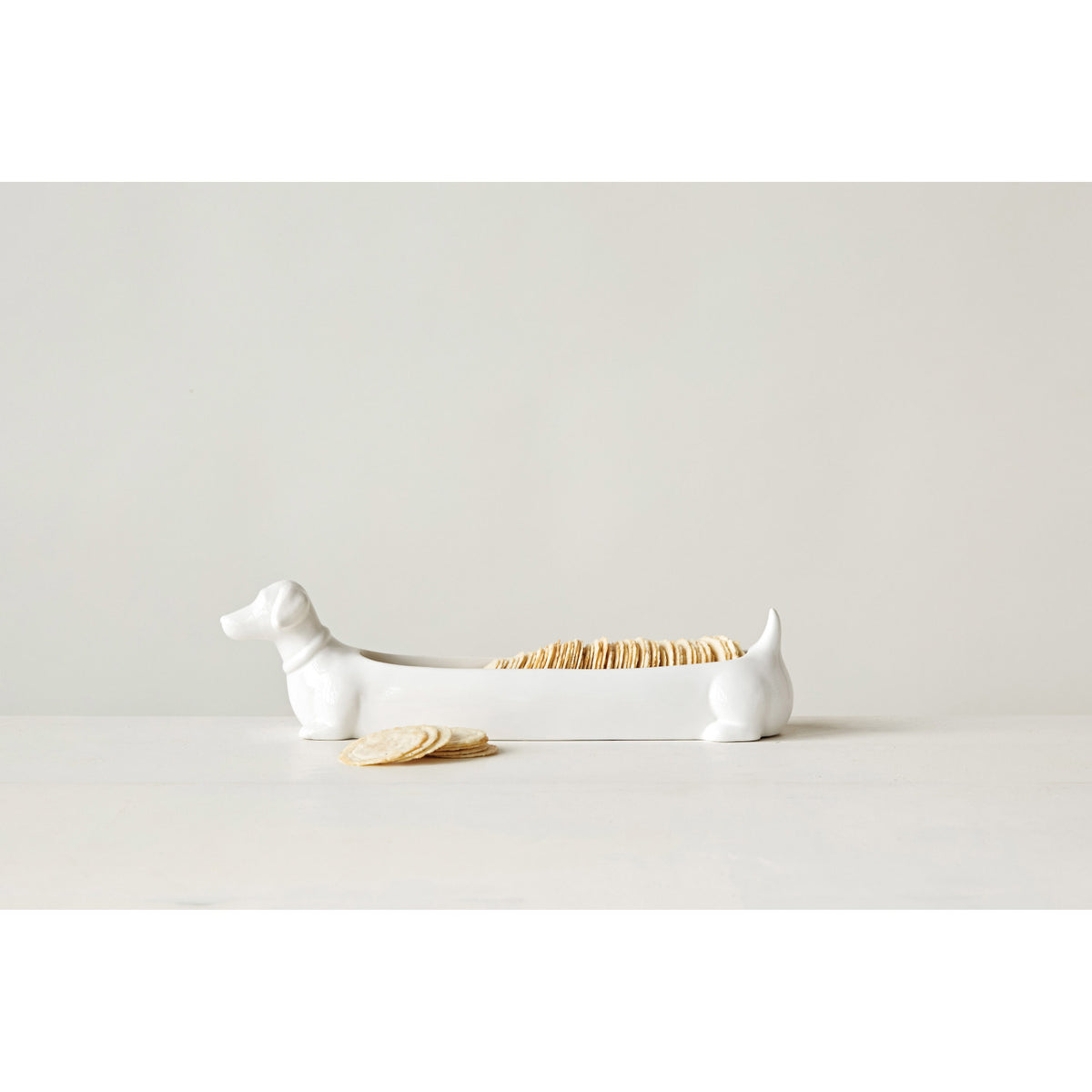 White ceramic dachshund cracker dish filled with crackers