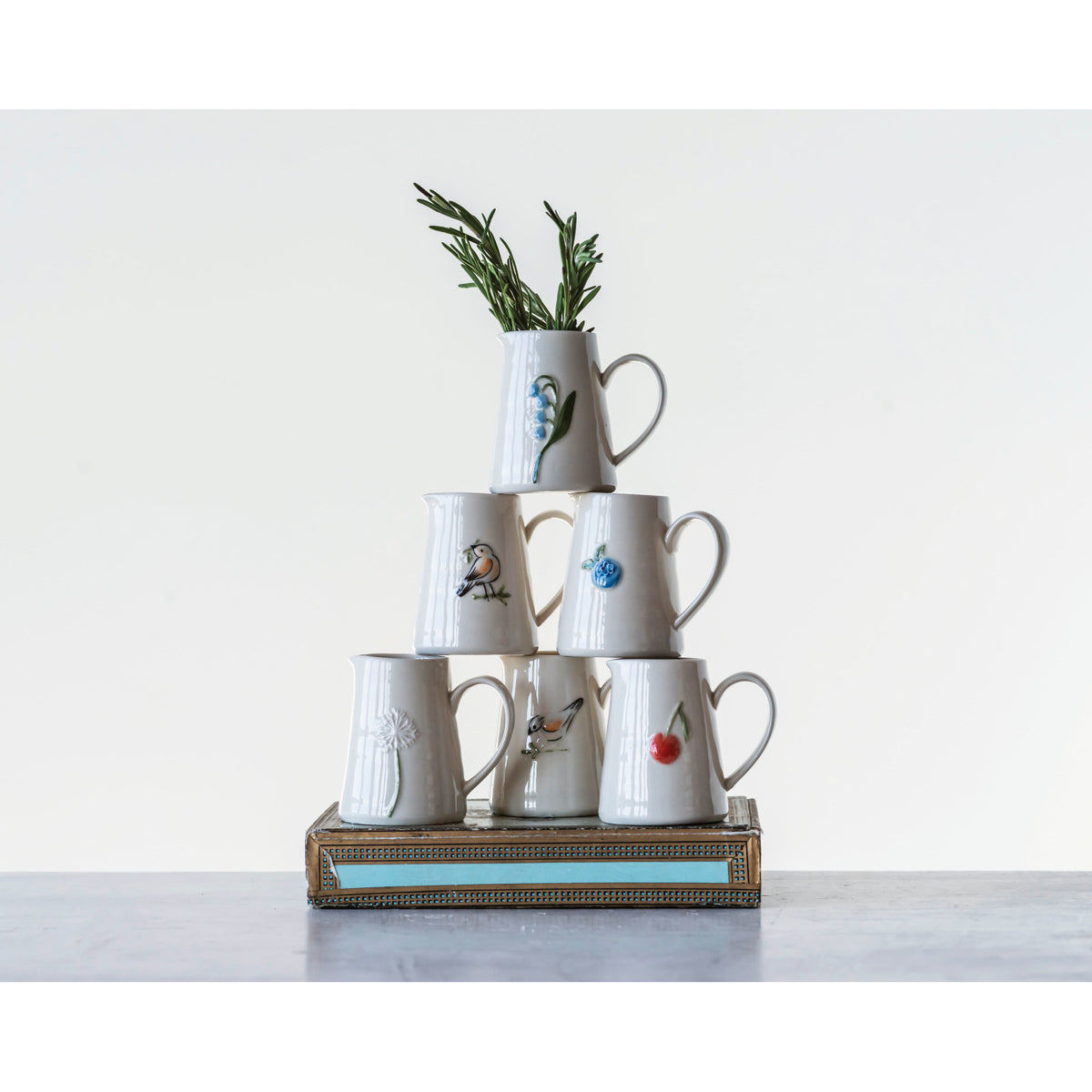 Six mini hand-painted stoneware creamers with floral fruit and bird designs