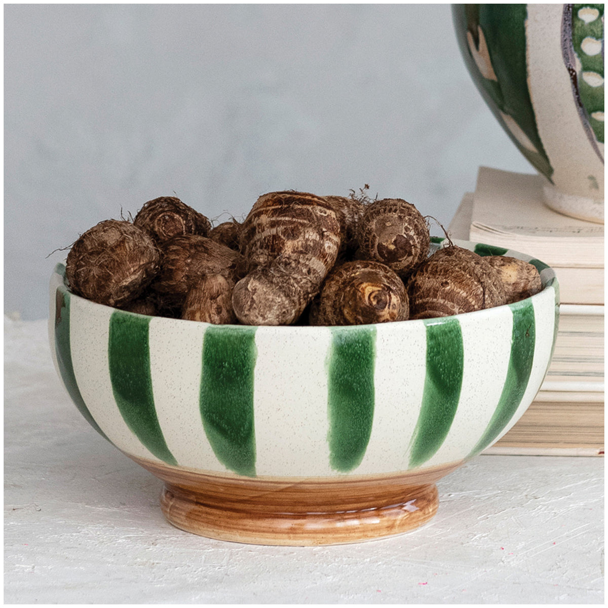 Green stripe stoneware footed bowl styled as a decorative kitchen serving bowl