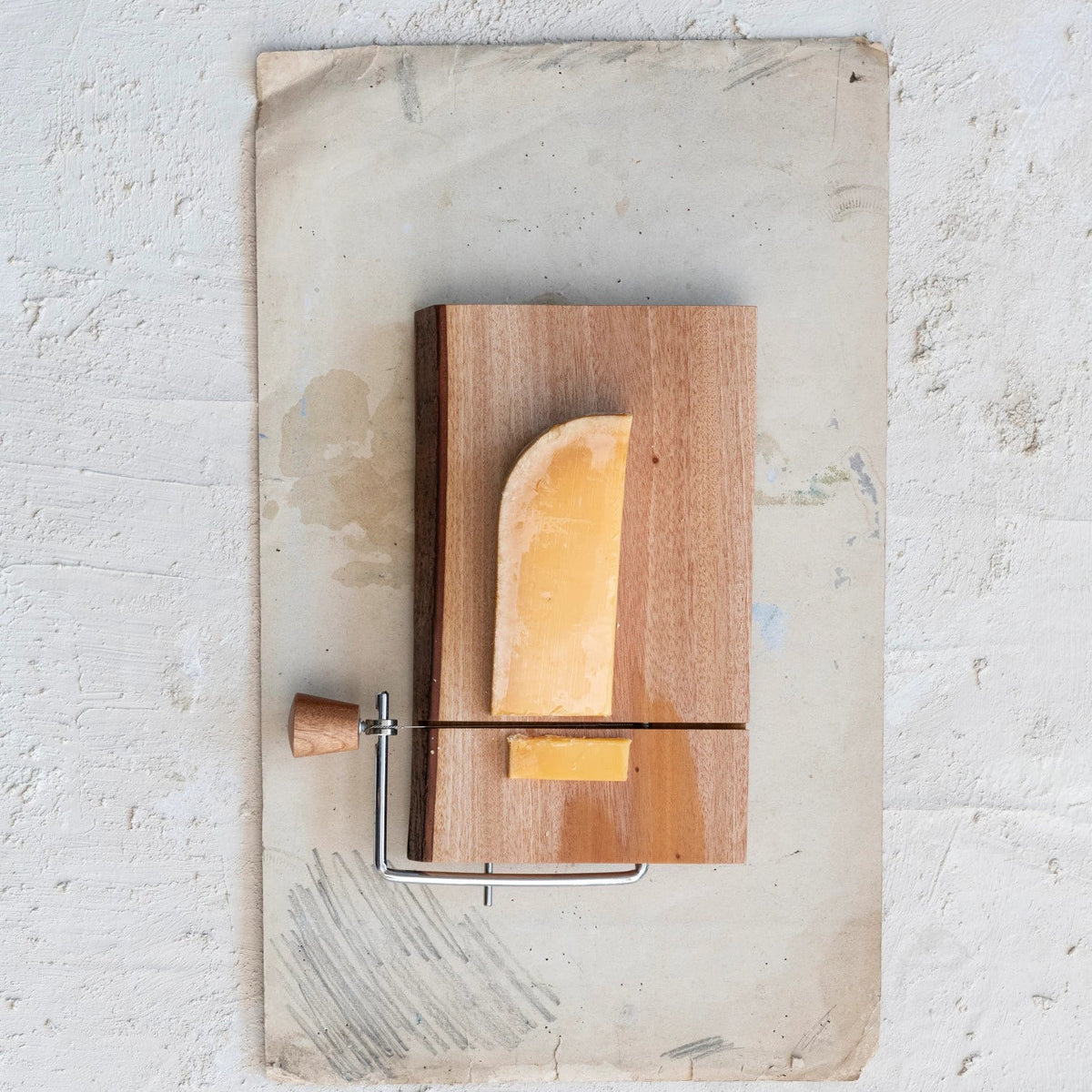 Live edge mahogany wood cheese slicer with natural bark edge and stainless steel wire
