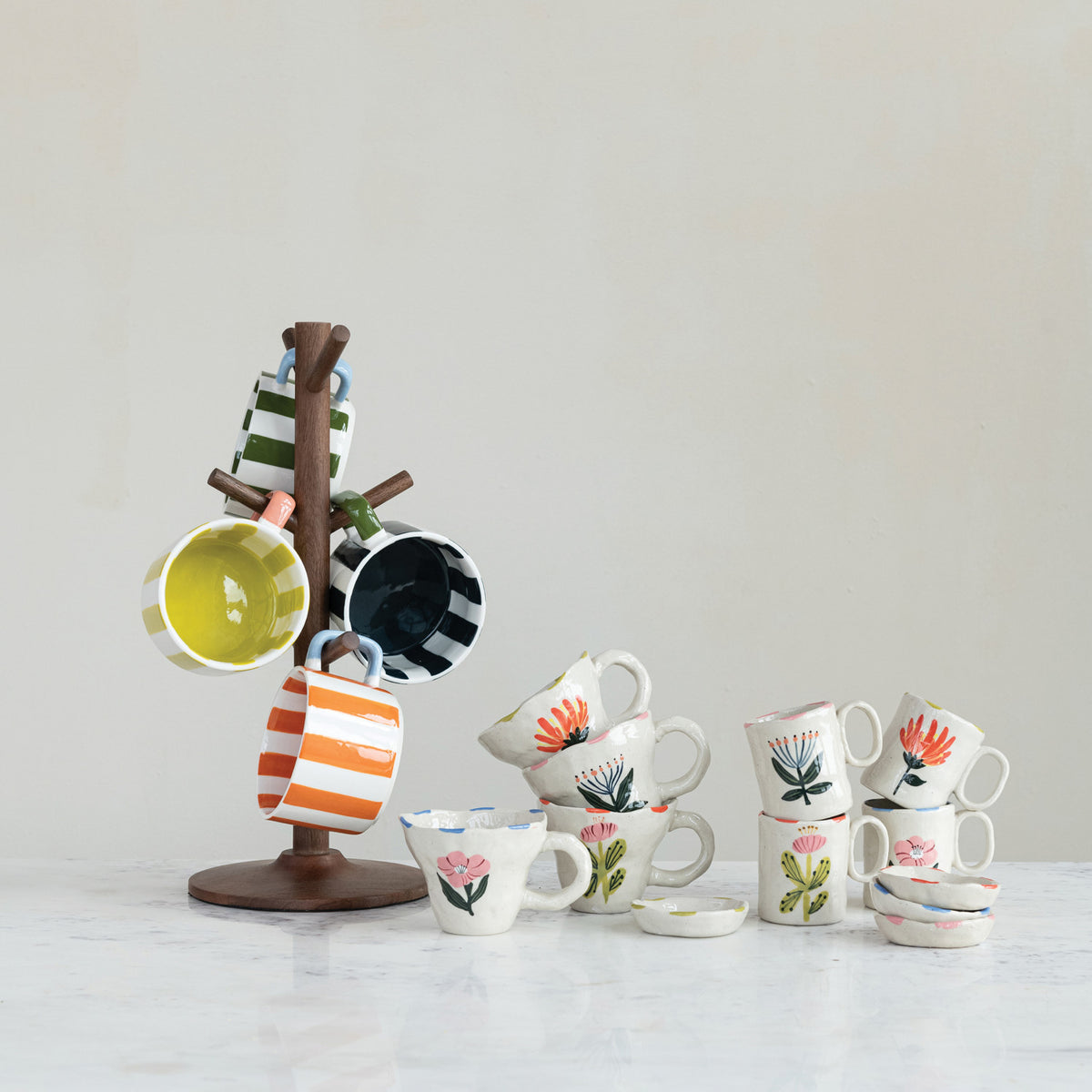 Colorful Market Stripe stoneware coffee mugs displayed with Wildflower Garden floral mugs on wooden mug tree