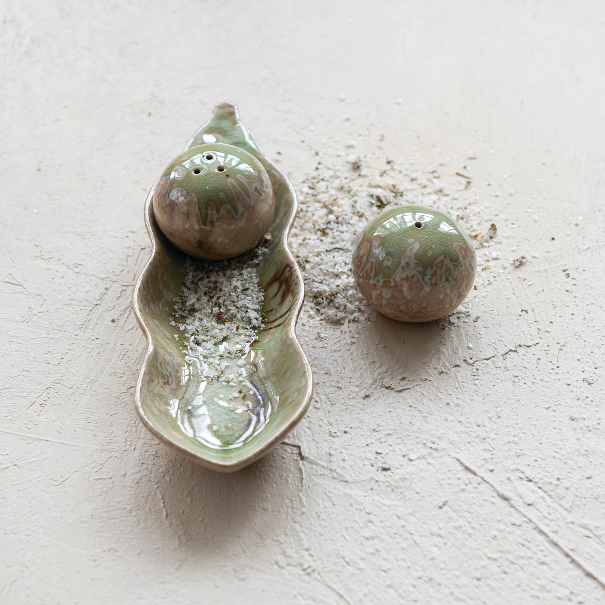 Peas in a pod stoneware salt and pepper shakers styled on a kitchen table