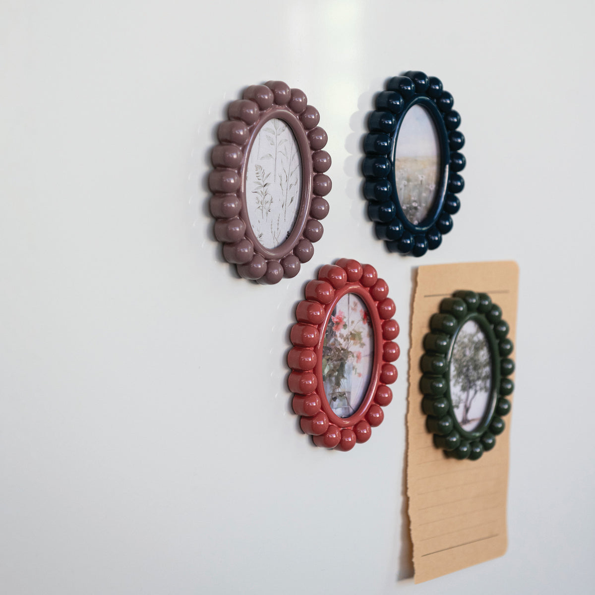 Colorful oval resin photo frame magnets displayed on refrigerator