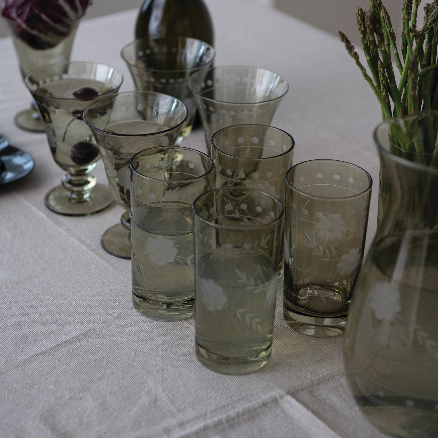 Green etched floral drinking glasses styled on a dining table