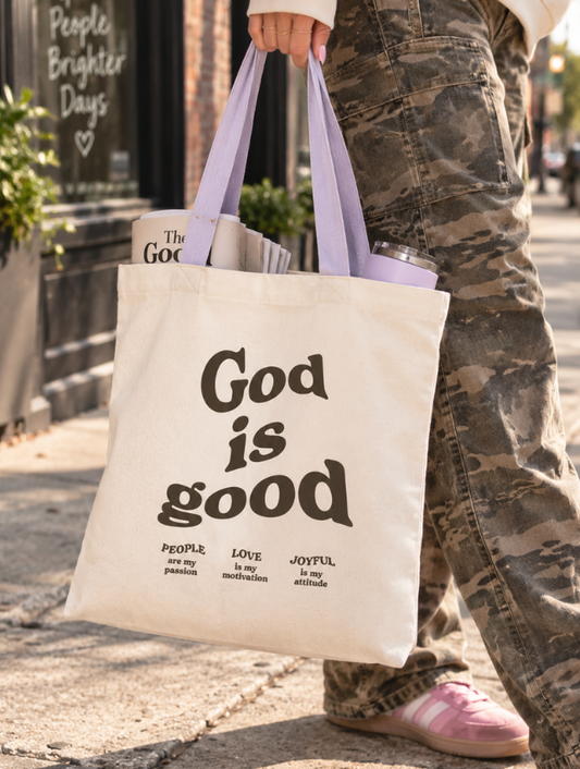Woman carrying God Is Good Christian canvas tote bag with lavender handles