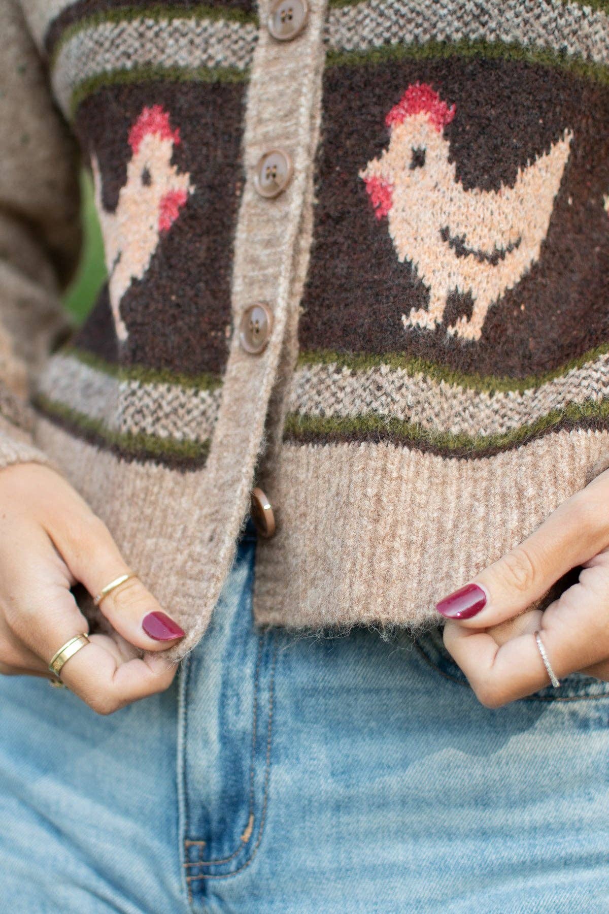 Detailed view of oatmeal speckled knit texture, round neckline and classic buttons on Heritage Chicken Cardigan.