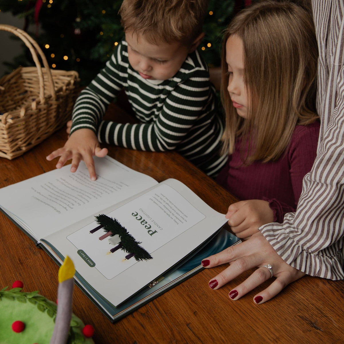 The Advent Storybook by The Daily Grace Co showing colorful Bible illustrations, daily family discussion questions and Christian Christmas readings.