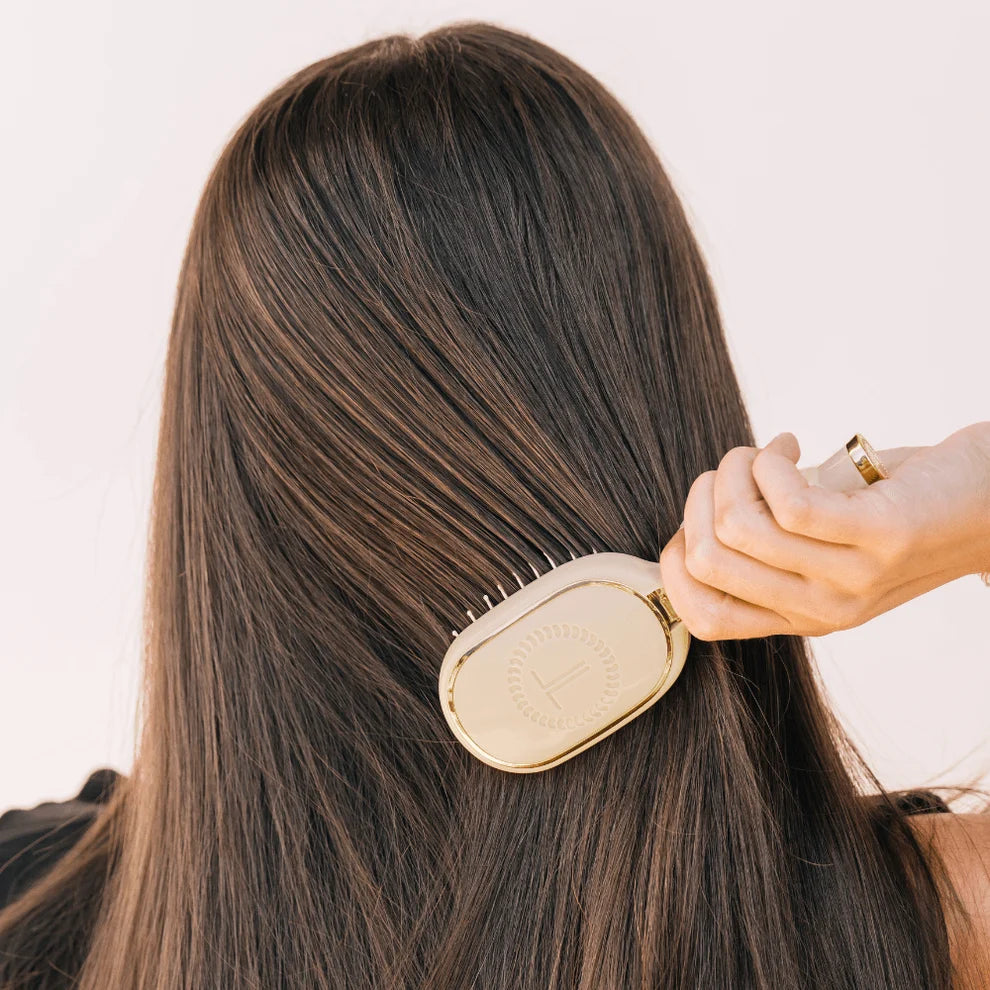 TELETIES Tan detangling hair brush being used on medium length brown hair