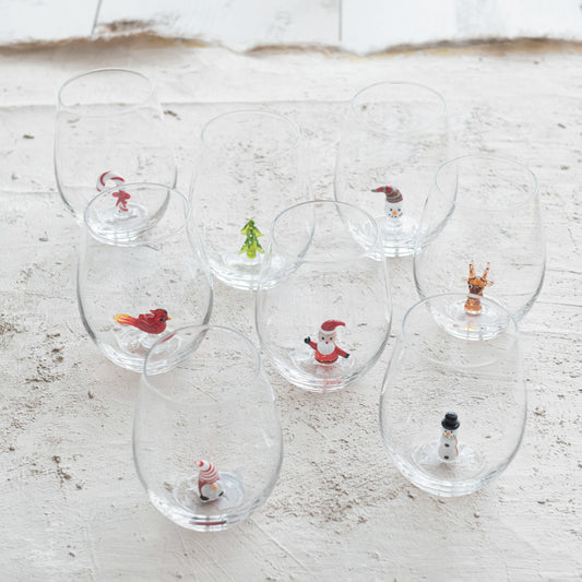 Assorted Christmas stemless wine glasses with miniature Santa snowman reindeer cardinal tree and candy cane figures
