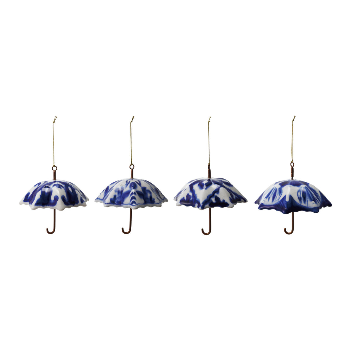 Blue and white stoneware umbrella Christmas ornaments hanging from a branch in four assorted designs