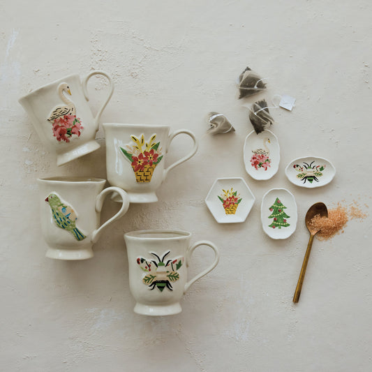 Hand-painted stoneware footed mugs with bird, swan, flower basket and bee designs styled for holiday entertaining