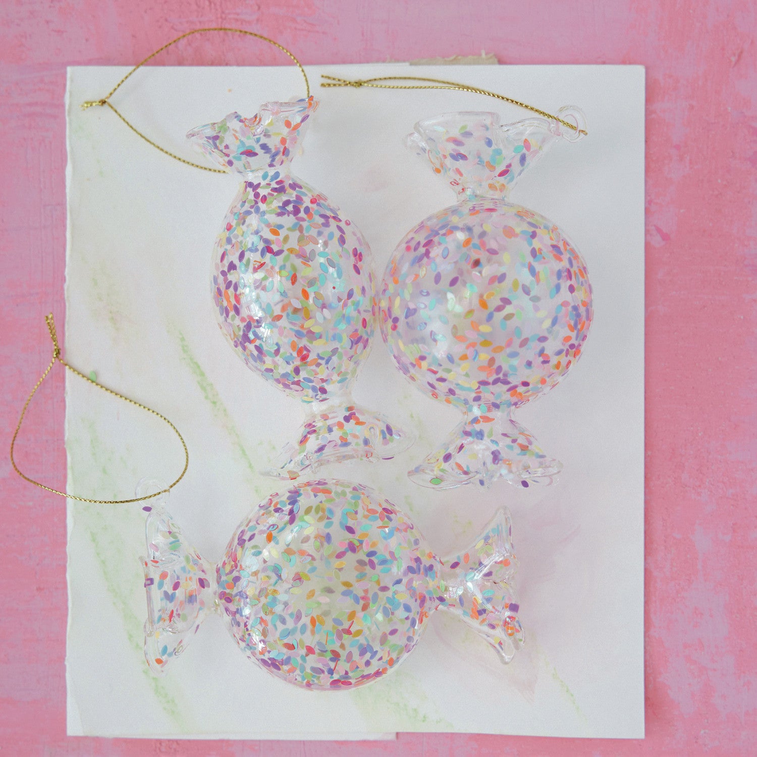 Colorful confetti candy glass Christmas ornaments with gold hanging cords
