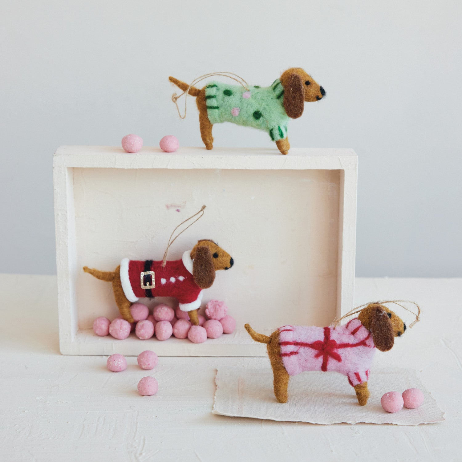 Wool felt dachshund Christmas ornaments wearing red mint green and pink holiday sweaters